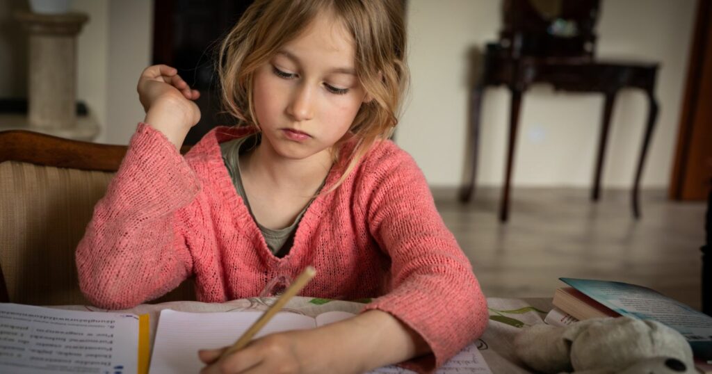 A képen egy kislány bal kézzel ír