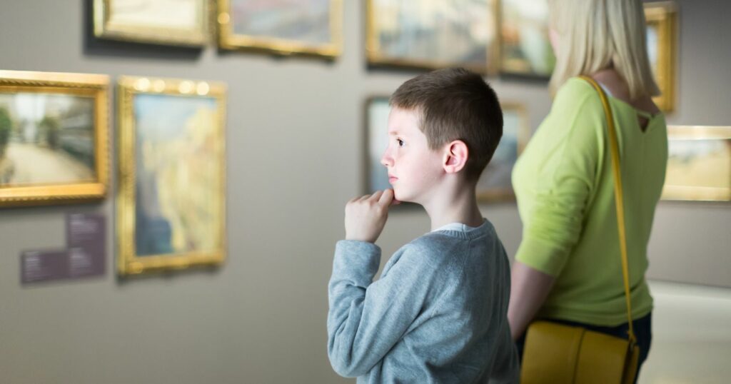 Egy kisfiú a múzeumban képeket néz az anyukájával