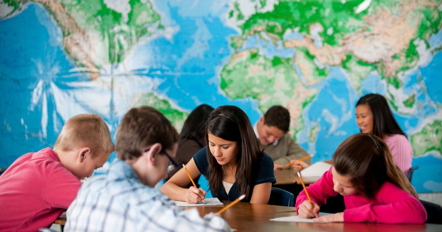 PISA felmérés - tanulók a tanteremben, mögöttük világtérkép