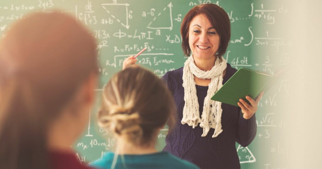 A képen egy női tanár matematikát oktat diákoknak