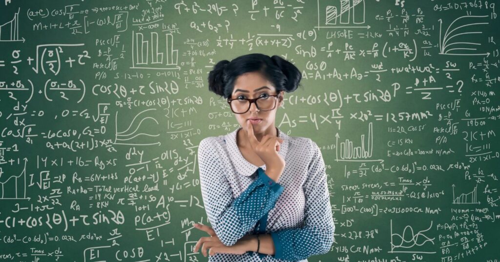 Fiatal lány egy matematikai képletekkel teleírt tábla előtt gondolkodik.