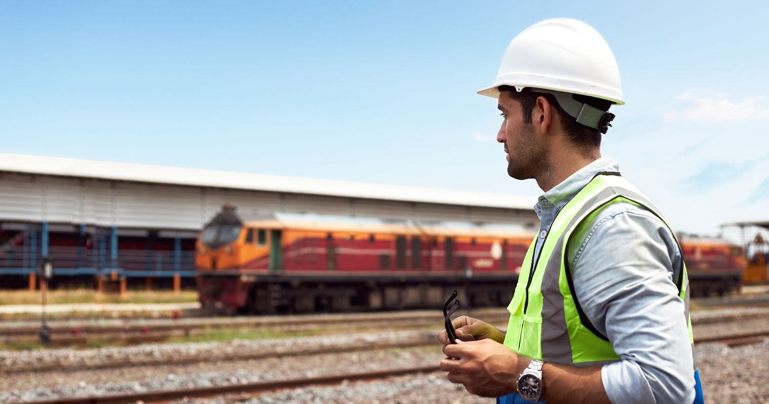 vasútforgalmi szolgálattevő technikus szakma leírása - férrfi munkaaruhában vonatokat ellenőriz