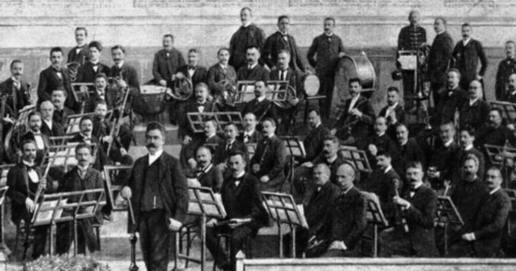 Budapesti Filharmóniai Társaság Zenekara fekete fehér képe, a zenekar és előttük a karmester.