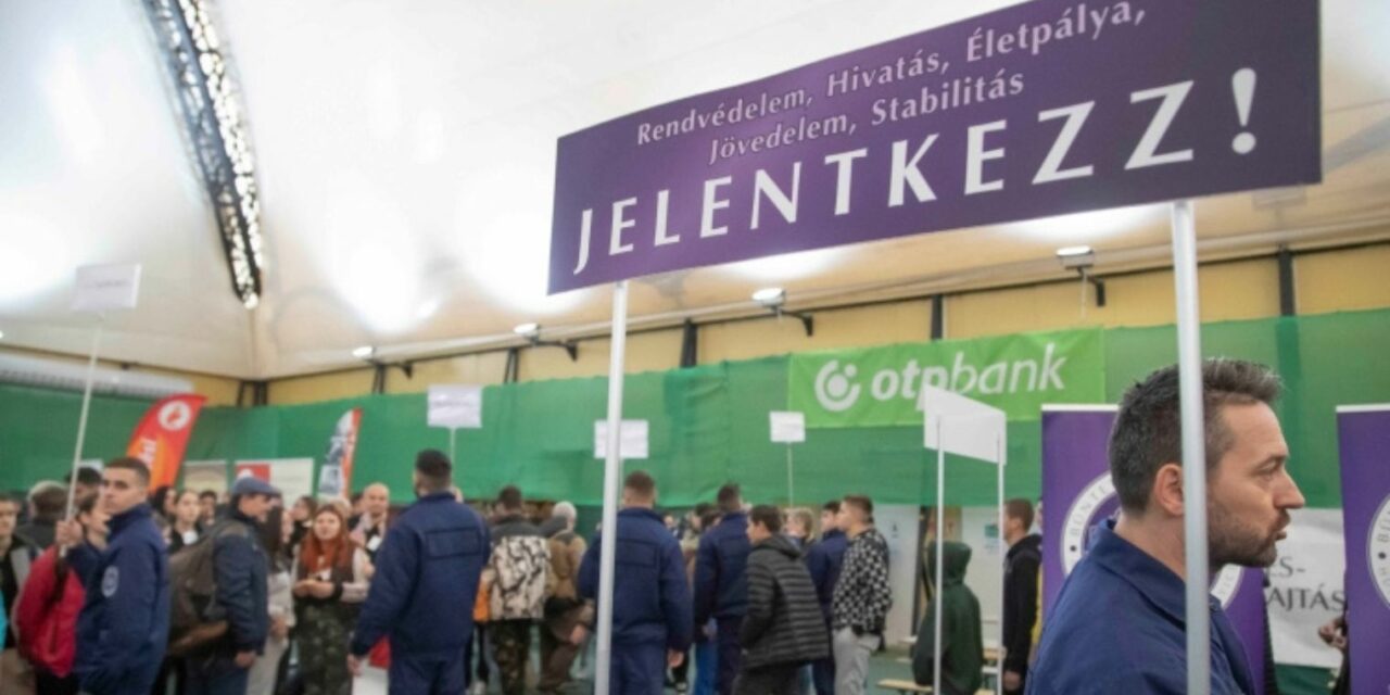 Rendvédelmi pályaorientációs napon egy Jelentkezz! feliratú stand és körülötte gyerekek és felnőttek állnak.