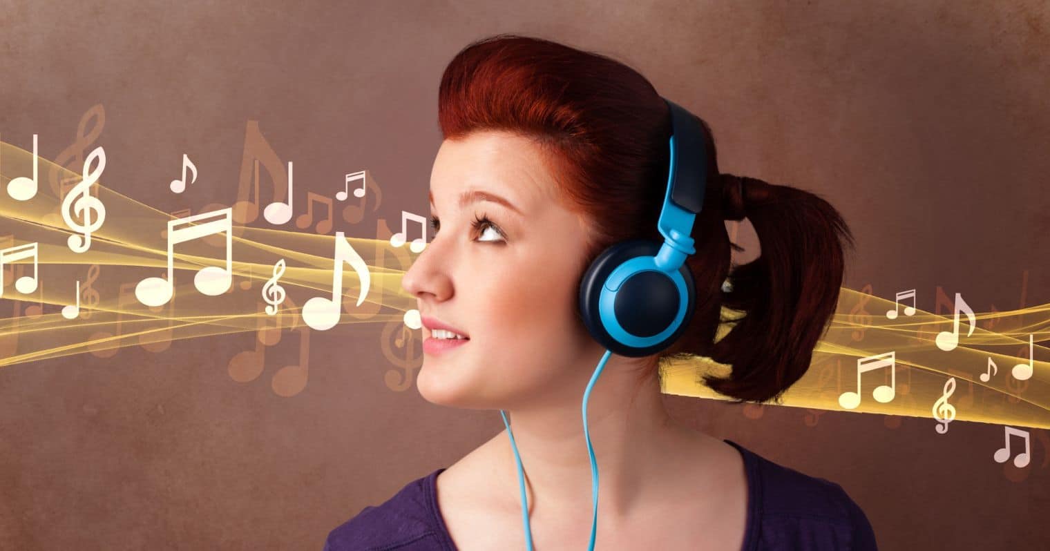 A képen egy zenét hallgató fiatal nő látható.