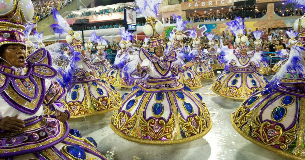 Színes szoknyákba öltözött nők rengetege táncol a karneválon.